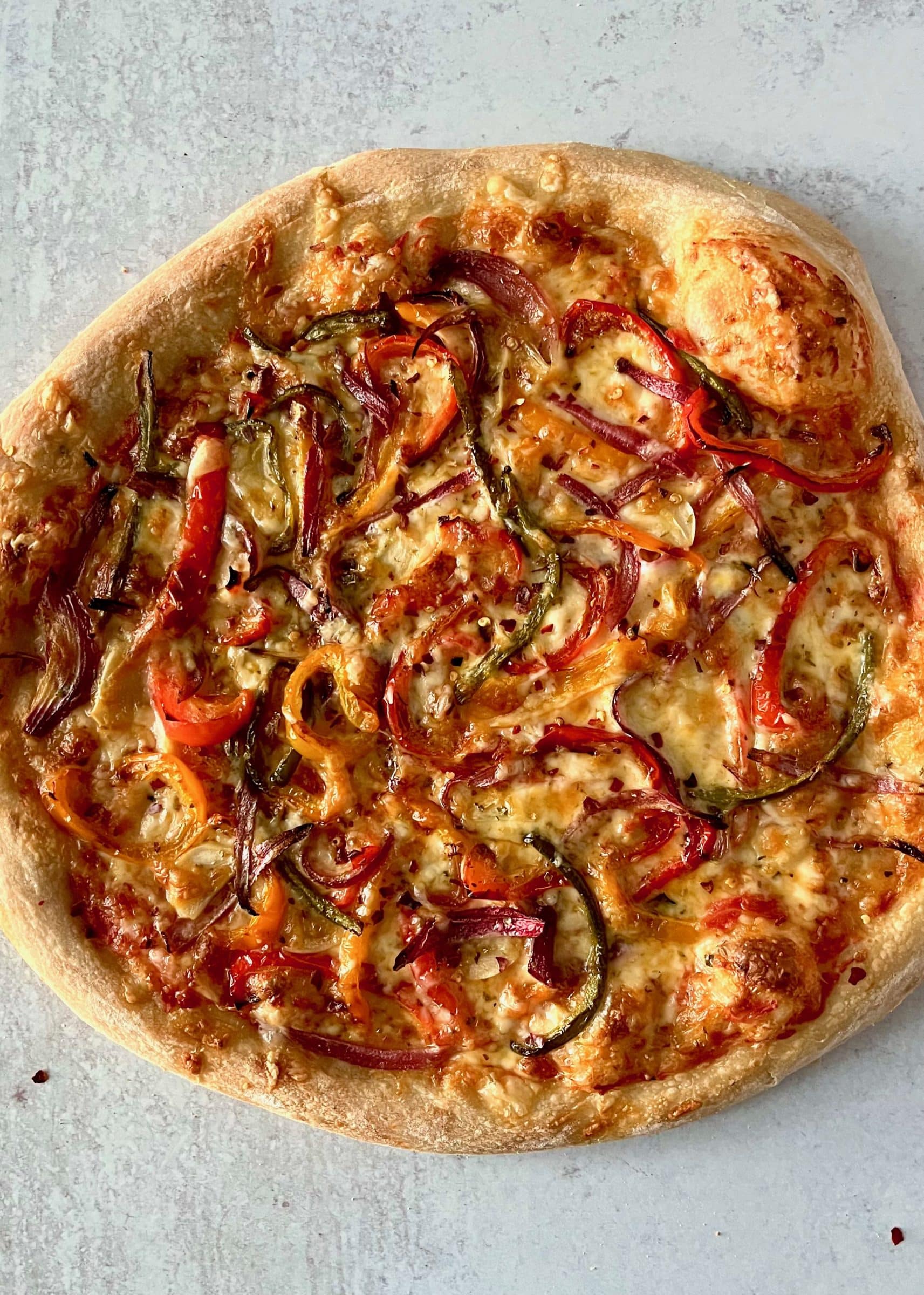 Pizza topped with roasted colorful peppers and onions